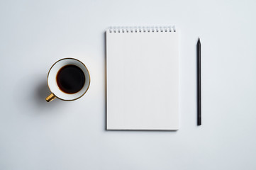 white office Desk top view with Notepad, pencil and coffee Cup, minimalistic design, top view,copy space,flat lay