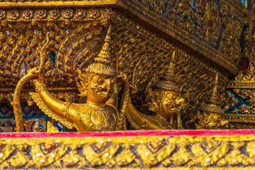 The beautiful Thai art and architecture. golden statue under golden Church wall in wat pra kaew/Bangkok, Thailand