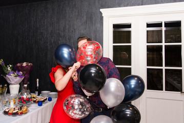 The guy and the girl cover their faces with colorful balloons. Jokes.