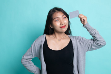 Young Asian woman think with a blank card.