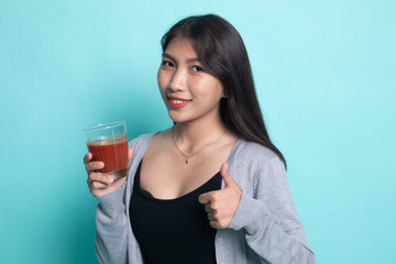 Young Asian woman thumbs up with tomato juice.