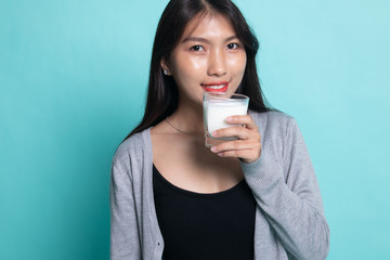 Healthy Asian woman drinking a glass of milk.