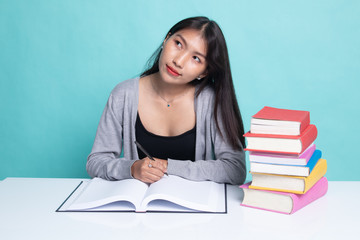 Young Asian woman read a book with books on table.