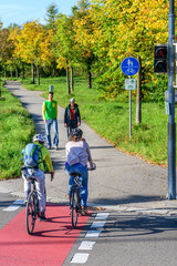 Radfahrer fahren vom Radweg auf einen kombinierten Rad- und Gehweg mit Fußgängern