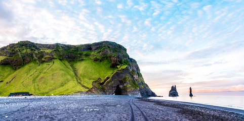 Beautiful dramatic landscape with cave in basalt rock on the black sand beach on Reynisdrangar Sea...