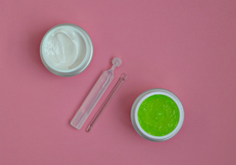 face cream, serum, aloe gel mask, on a pink background, close-up