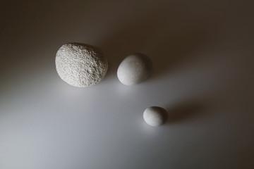 Composizione di sassi raccolti in spiaggia: a uovo e pomice, su fondo bianco