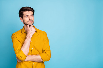 Photo of freelancer guy seriously looking side empty space holding arm on chin thinking over...