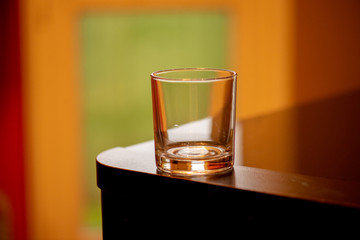 empty glass on a table with orange background