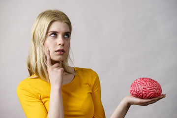 Woman thinking holds brain
