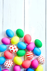 Easter eggs. Many colorful chicken eggs on white wooden background, top view