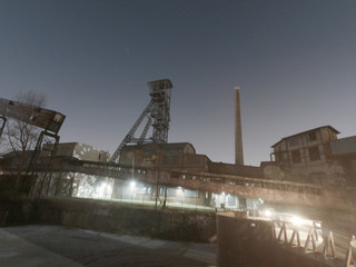 Obraz premium Old closed industrial ironworks at night. Epic metal structures and chimneys lit by the moon