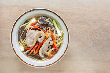 top view of stir fried duck meat with ginger and vegetable in a ceramic dish on wooden table. homemade style hot and spicy food menu.