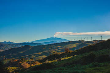 View of windmills and the mount Etna Volcano