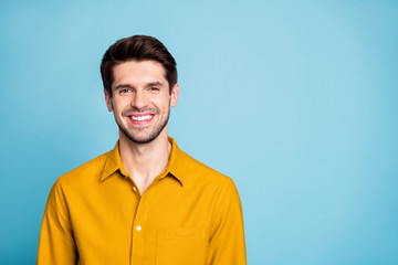 Photo of handsome creative executive director wearing yellow shirt smiling toothily isolated over blue pastel color background