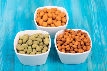 Mix of nuts in wasabi and spice batter on wood background.