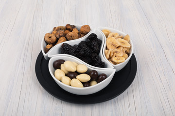 Mix of dried fruits and nuts on a wood background. Symbols of christmas holiday.