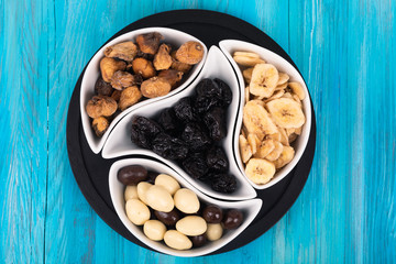 Mix of dried fruits and nuts on a wood background. Symbols of christmas holiday.