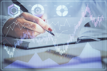 Multi exposure of woman's hands making notes with forex graph hologram. Concept stock market analysis.