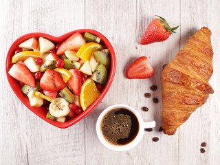 fruit salad, croissant and coffee cup- top view