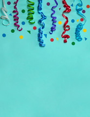 The concept of birthday. The frame is made of paper decorations, garlands of flags, confetti and streamers, blowouts, candles for cakes and balloons on a pink background.