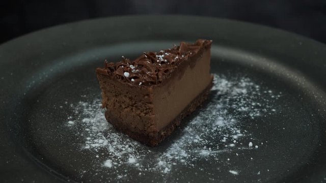 Delicious brown Chocolate Cake rotating on a black background - Stock 4K Video Clip Footage