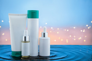 Cosmetic products standing in water with ripples.