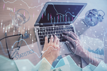 Multi exposure of forex graph with man working on computer on background. Concept of market analysis.