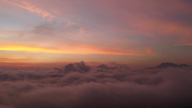 The beautiful fiery orange sunset view above the clouds of Bali, Indonesia - Aerial shot