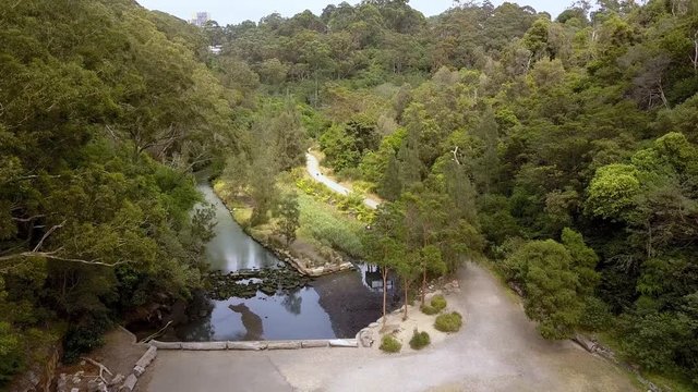 Aerial flyover of Flat Rock Creek canyon in Northbridge just past the Long Gully Bridge, Sydney Australia, drone forward shot