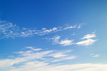 Beautiful cirrus and stratus clouds high in a bright blue sky on a sunny day. Different cloud types and atmospheric phenomena. - obrazy, fototapety, plakaty