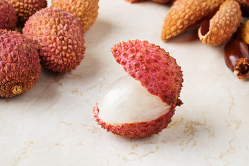 Close-up of juicy ripe lychee fruit (Litchi chinensis) on a white kithen table. Fruits and vegetables, vegetarian and healthy eating. Ready to eat. Front view.