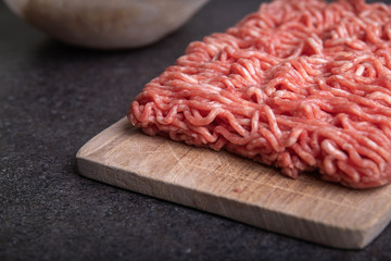Minced Meat (Beef) as detailed close-up shot on dark background