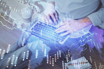 Forex graph with businessman working on computer in office on background. Concept of analysis. Double exposure.