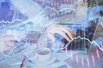 Forex graph with businessman working on computer in office on background. Concept of hardworking. Multi exposure.