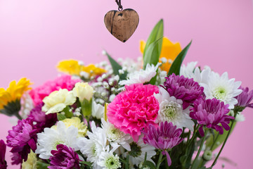 beautiful flowers with heart on pink background