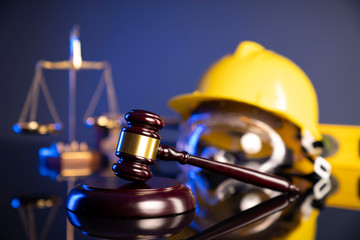Construction law. Helmet and gavel on the blue background.