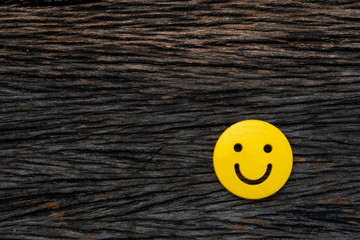 smiley face icon symbol on vintage dark hard wood table background