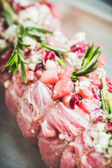 Raw pork loin with fruits, blue cheese and rosemary ready for baking. Selective focus. Shallow depth of field.