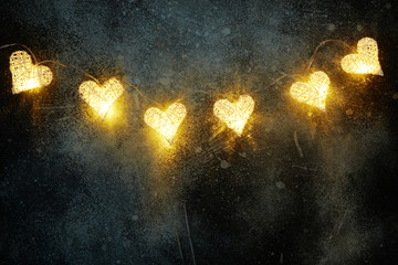 Beautiful heart-shaped fairy lights glowing on dark . St. Valentine's Day background