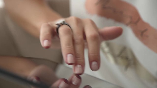 Close-up: female hands with delicate manicure touchscreen, scroll page