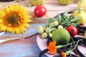 Bright fresh vegetables, fruits and flowers on a wooden table, healthy food
