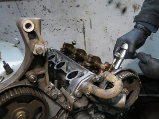 The connecting rod, piston and cylinder block in a disassembled condition. Man s hand fixing a engine