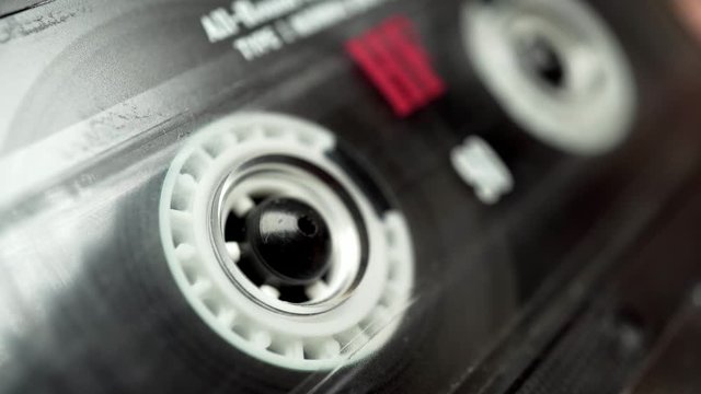 Retro audio tape copmact cassette is playing music.
