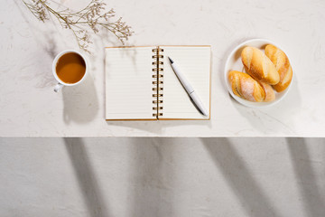 Taking a Cup of coffee,  book and croissants on white background. Top view.