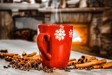 Mug of hot mulled on table.Free space for your decoration.Blurred background of fireplace in...