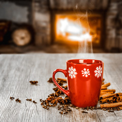 Mug of hot mulled on table.Free space for your decoration.Blurred background of fireplace in...