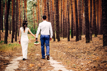 A guy with a girl walk through the forest along a country road in the mountains after rain