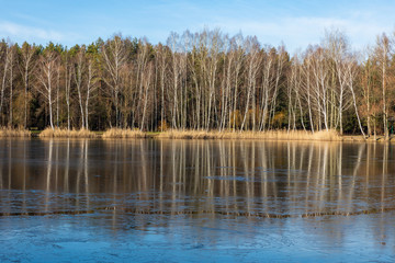 Frozen winter lake and forest in Poland.