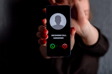 Phone call from unknown number. Scam, fraud or phishing with smartphone concept. Prank caller, scammer or stranger. Woman answering to incoming call. Hoax person with fake identity.